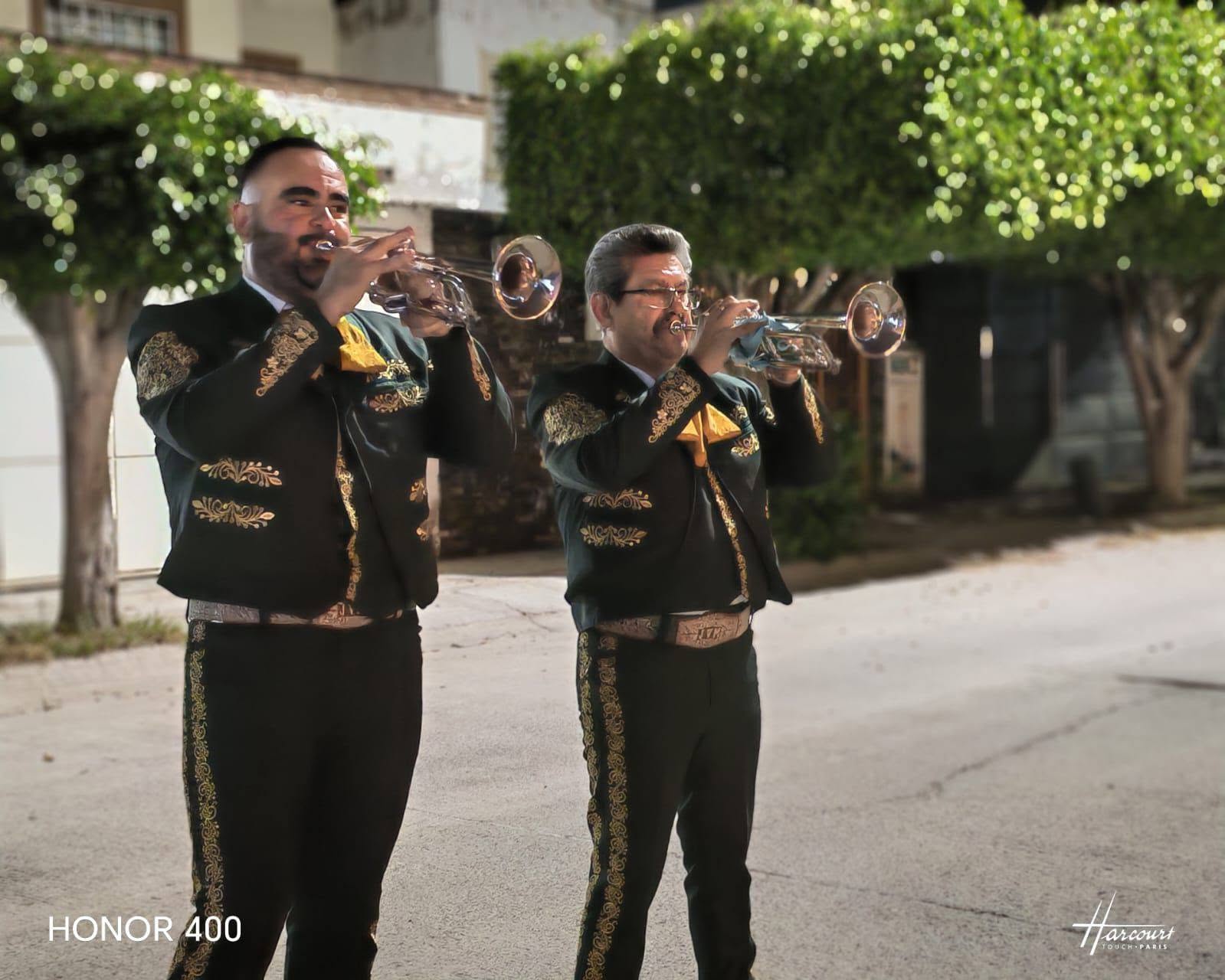 Dos trompetistas con traje charro verde y bordados dorados